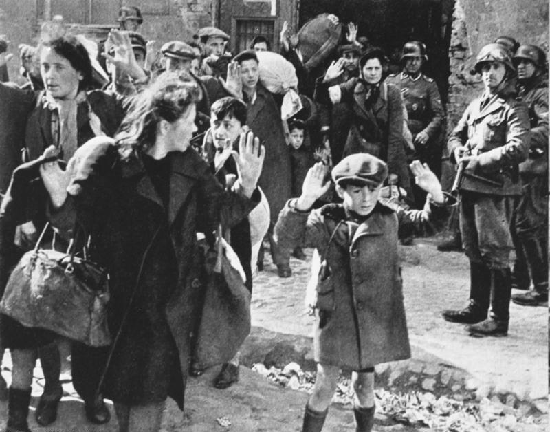 Ein jüdischer Junge, der sich im April 1943 während des Aufstands im Warschauer Ghetto versteckt hat, stellt sich der SS. Rechts im Bild mit der Maschinenpistole der SS-Unterscharführer Josef Blösche, um den es auch in dem Dokumentarfilm geht. (Copyright: Bundesarchiv Bild 183-41636-0002)